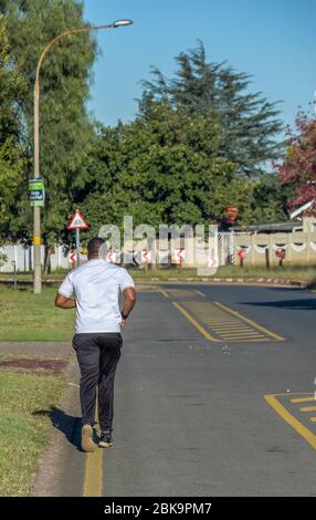 Alberton, Südafrika - unbekannte Bewohner im Vorort Brackendowns, die während der 4. Ebene der nationalen Sperre das Übungsfenster benutzen Stockfoto