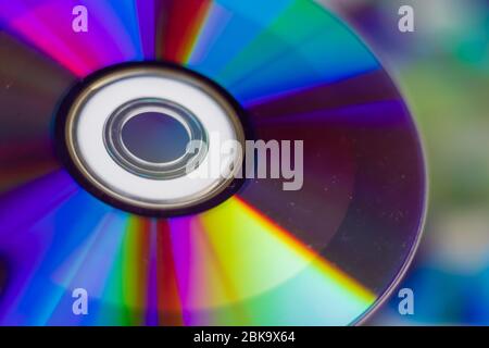 Compact Disc Eine CD in Händen halten. Die Rückseite der CD reflektiert farbenfrohe Lichter. Regenbogenfarben. Stockfoto