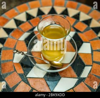 11 von oben nach unten traditioneller türkischer Früchtetee in einer Glasschale und Untertasse auf einem dekorativen Tisch Stockfoto