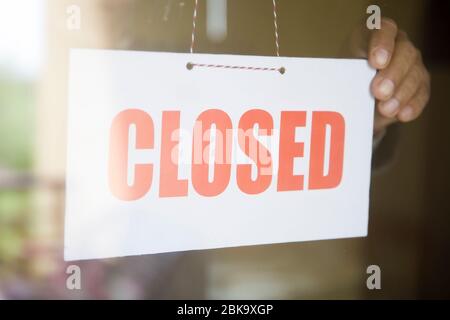 Geschäftshausbesitzer, der sich am Eingang des Glasgeschäfts abschließt Stockfoto