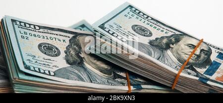 Isoliertes Bündel von Dollar. Ein großer Stapel von hundert-Dollar-Scheinen liegt diagonal über dem weißen Hintergrund des Bildes. Nahaufnahme. Kontrastreiche CO Stockfoto