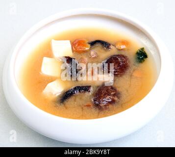 Japanische Suppe mit Shiitake-Pilzen. Suppe mit Soja-Käse leckere gesunde Lebensmittel. Diätsuppe mit Pilzen. Suppe in einer Schüssel. Stockfoto