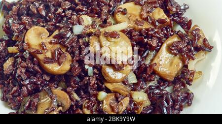 Schwarzer Reis Risotto mit Pilzen und karamellisierten Zwiebeln Stockfoto