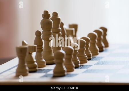 7/8-Ansicht von Schachbrett mit weißen Schachfiguren auf Holzmöbeln im Landhausstil Oberfläche Stockfoto