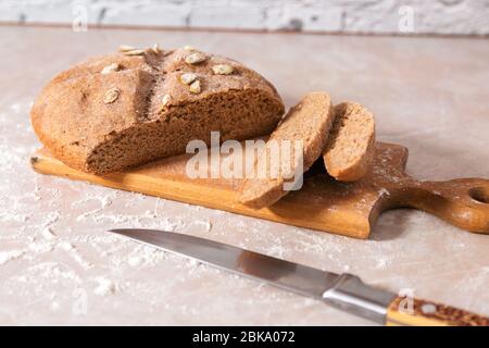 Frisches gesundes Brot mit Kürbiskernen auf Holzbrett geschnitten Stockfoto