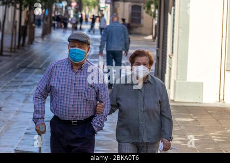 Barcelona, Spanien. Mai 2020. Seniorenpaar trägt Schutzmaske und geht Hand in Hand auf den Straßen von Barceloneta während der Covid-Sperre Stockfoto