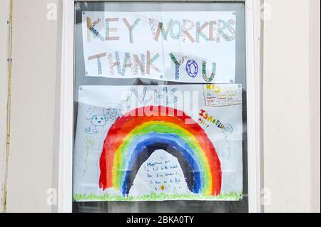 Bunte Gemälde von Regenbögen von Kindern in Fenstern ausgestellt, um dem NHS und den Schlüsselarbeitern während der Covid-19 Pandemie zu danken. Stockfoto