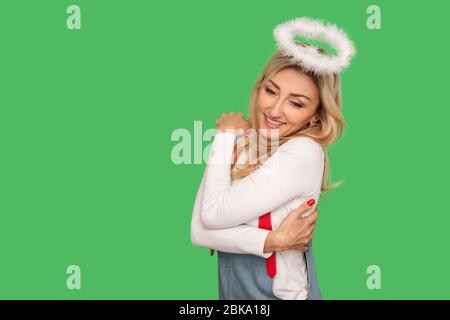 Positives Selbstwertgefühl. Porträt der engelhaften erwachsenen Frau umarmt sich und lächelnd, zufrieden mit ihrem Aussehen, keine Unsicherheiten, Selbstliebe Konzept Stockfoto