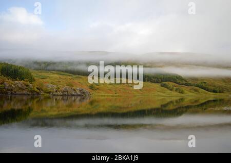 Am frühen Morgen steigt im Herbst der Nebel im Loch Lubhair Trossachs National Park, Schottland Stockfoto