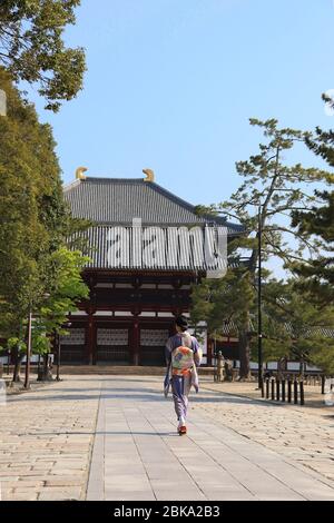 Japanische Frau im Kimono, die zu einem buddhistischen Tempel geht Stockfoto