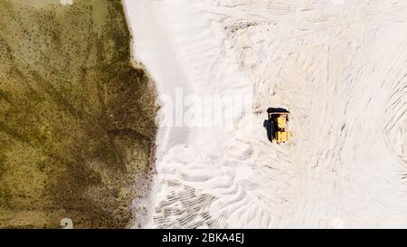 Gelbe Bulldozer im Sandsteinbruch. Dronesicht Von Oben Nach Unten. Geometrische Formen in der Natur. Stockfoto