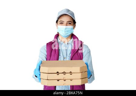 Hispanic Frau Kurier trägt Maske Handschuhe halten Pizza-Boxen isoliert auf weiß. Stockfoto