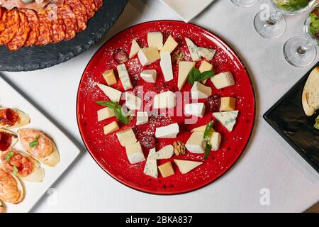 Verschiedene Käsesorten auf einer roten Platte Stockfoto