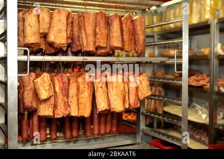 Ein Arbeiter in der Fleischverarbeitungsfabrik bereitet am Arbeitstisch Würstchen zu. Lebensmittelindustrie und verarbeitende Industrie. Rohes Fleisch Mischung: Steaks, Geflügel Stockfoto