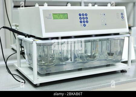 Eine Chemikerin führt Löslichkeitstests von Tabletten und anderen Darreichungsformen durch. Erveka - Wissenschaftliche Forschung Pharmazeutisches Labor. Ein Mann führt Stockfoto