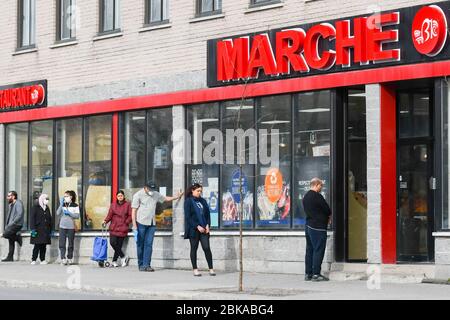 Menschen Schlange vor Supermarkt unter Wahrung der sozialen Distanz in der Einwanderer-Arbeitsviertel Park Extension in Montreal Kanada Stockfoto