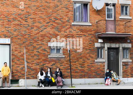 Menschen warten auf den Bus während der Covid 19 Pandemie , in Park Extension , einem Einwanderungsviertel von Montreal Kanada Stockfoto