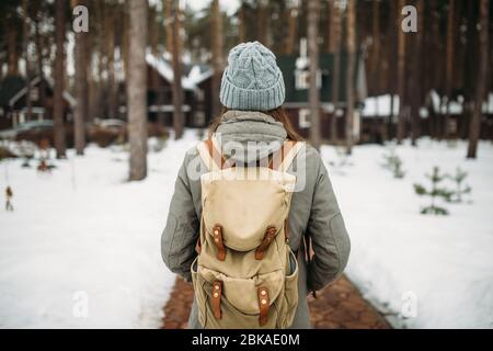 Das Mädchen steht mit dem Rücken im Winter im Wald Stockfoto