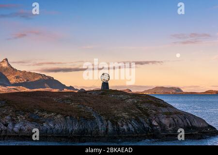 Das Polarkreis-Denkmal auf 66 Grad 33’ Norden auf der Insel Vikingen, mit der Insel Hestmona dahinter: Rødøy, Nordland, Norwegen Stockfoto