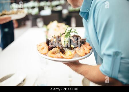 Kellner serviert Garnelen Stockfoto