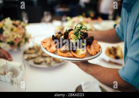 Kellner serviert Garnelen Stockfoto