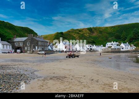 Strand und Gebäude im Weiler Porthdinllaen auf der Halbinsel Llyn in Wales, aufgenommen bei Ebbe an einem sonnigen Tag im Sommer Stockfoto