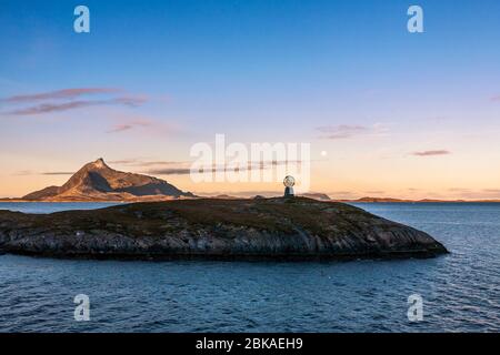 Das Polarkreis-Denkmal auf 66 Grad 33’ Norden auf der Insel Vikingen, mit der Insel Hestmona dahinter: Rødøy, Nordland, Norwegen Stockfoto