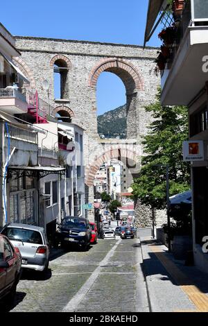 Kavala, Griechenland - 13. Juni 2019: Autos in einer engen Straße mit mittelalterlichem Aquädukt Kamares Stockfoto