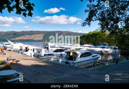 Die Vergnügungsboote von Touristen im Urlaub liegen im Urquhart Bay Harbour am Loch Ness im Great Glen, Schottland, Großbritannien - aufgenommen an einem sonnigen Tag Stockfoto