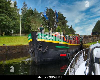 Der niederländische Hotelbarge Ros Crana verlässt ein Schloss am Caledonian Canal in den schottischen Highlands, Schottland. Stockfoto