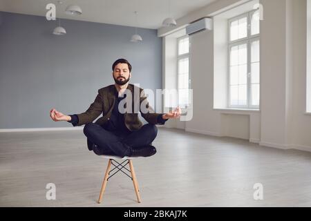 Ruhiger meditativer bärtiger Geschäftsmann entspannt sich auf einem Stuhl im Büro. Stockfoto