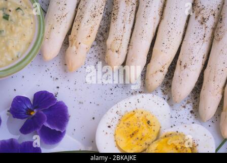 Bund frischer, ungekochter weißer Spargel und gekochte Eier, neue Ernte, aus nächster Nähe. Filtereffekt. Gemüse der Saison. Selektiver Fokus Stockfoto