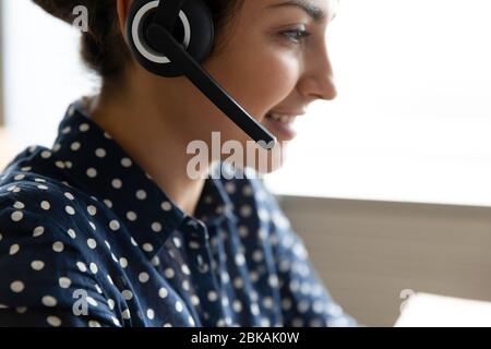 Angenehm ziemlich lächelnde indische Frau mit Headset mit Mikrofon. Stockfoto
