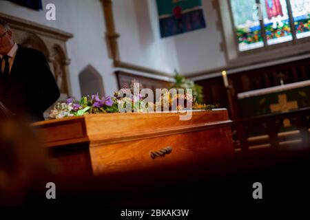 Einlone Sarg wartet, wie Trauerrede bei einer Beerdigung in einer ländlichen Kirche in Süd-UK Februar 2020 gelesen Stockfoto