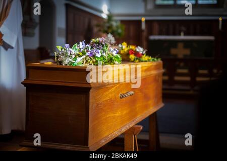 Einlone Sarg wartet, wie Trauerrede bei einer Beerdigung in einer ländlichen Kirche in Süd-UK Februar 2020 gelesen Stockfoto