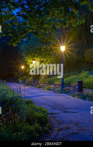 Zentraler Stadtpark in Luxemburg City bei Nacht, wenn die Dunkelheit einfällt, sind die Schatten lang und die Straßenlaternen sind bereits beleuchtet Stockfoto