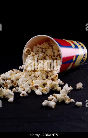 Nahaufnahme verschüttete Popcorn auf schwarzem Hintergrund. Stockfoto