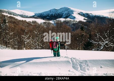 Bergsteiger steht im Winter in den verschneiten Bergen Stockfoto
