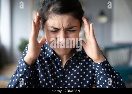 Indische Frau leidet an starken Kopfschmerzen oder lauten Geräuschen. Stockfoto