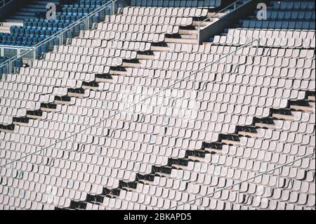 Leere sonnenbeleuchtete Stühle auf der Tribüne des Olympiastadions in Barcelona, Spanien Stockfoto