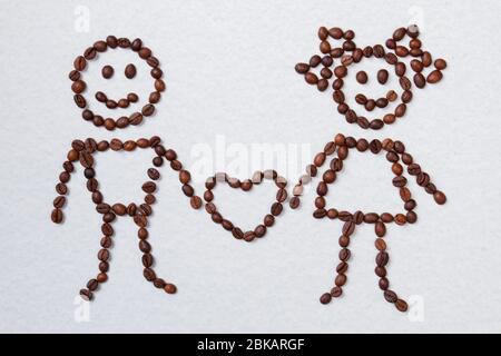 Kaffeebohnen in liebevollem Paar mit Herz angeordnet. Stockfoto