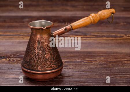Schließen Sie dekorative türkische Kaffeekanne auf Holztisch. Stockfoto
