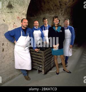 Virginie Taittinger, Gründerin ihres eigenen Champagnerlabels, umgeben von Mitarbeitern im Keller des Taittinger Hauses in Reims. Stockfoto