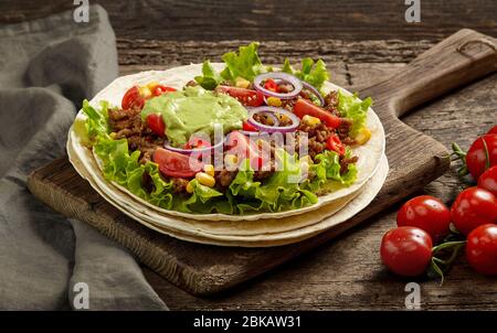 Tortilla Wrap mit gebratenem Hackfleisch und Gemüse auf Holztisch Stockfoto