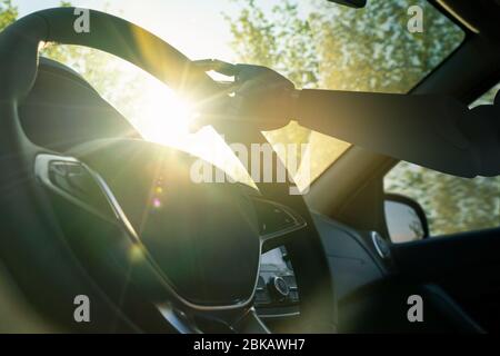 Roboterarm an einem Lenkrad. Künstliche Intelligenz treibt ein Auto. Autonomes Fahrzeugkonzept. Stockfoto