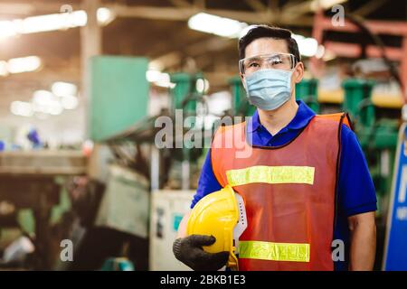 Asiatische Arbeiter tragen Einweg-Gesichtsmaske zum Schutz Corona Virus Verteilung und Rauch Staub Luftverschmutzung Filter in der Fabrik für gesunde Arbeit Pflege. Stockfoto