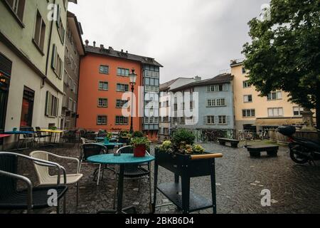 Café mit nassen Pflastersteinen vor einem grauen Himmel Stockfoto