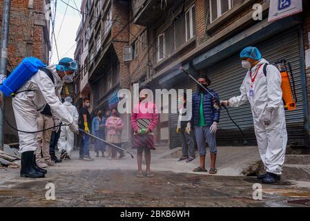 Kathmandu, Nepal. Mai 2020. Ein Kind, das mit Desinfektionsmittel als Vorsichtsmaßnahme gegen die Ausbreitung des Coronavirus während der Pandemie besprüht wird.Anwohner engagieren sich in ihrer Gemeinde, um ihre Mitbewohner inmitten der landesweiten Sperrzeit und der Bedrohung durch Corona-Viren zu desinfizieren. Kredit: Sunil Pradhan/SOPA Images/ZUMA Wire/Alamy Live News Stockfoto