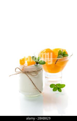 Hausgemachter süßer Joghurt mit Scheiben eingelegter Pfirsiche in einem Glasgefäß Stockfoto