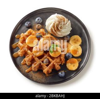 Teller mit belgischen Waffel Dessert mit Sahne und Früchten isoliert auf weißem Hintergrund, von oben Stockfoto
